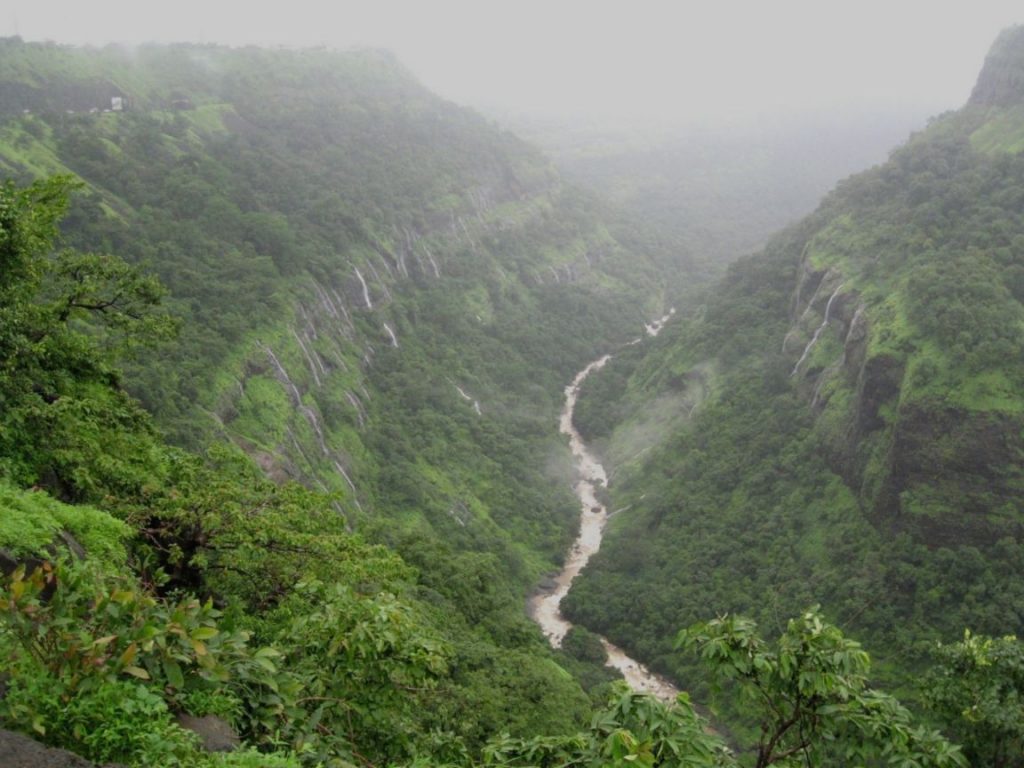 Arial view of Lonavala displaying lush forests with a river running through the center